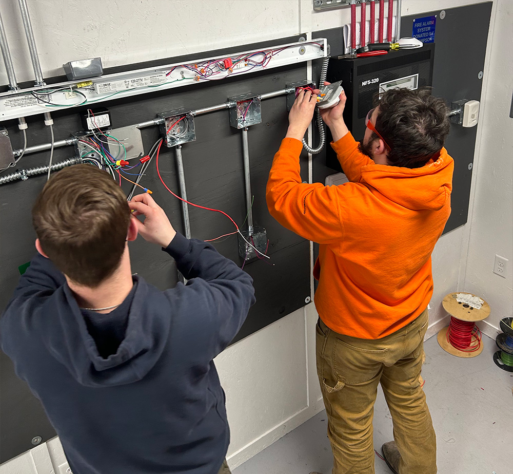 Students working on electrical projects in a classroom.