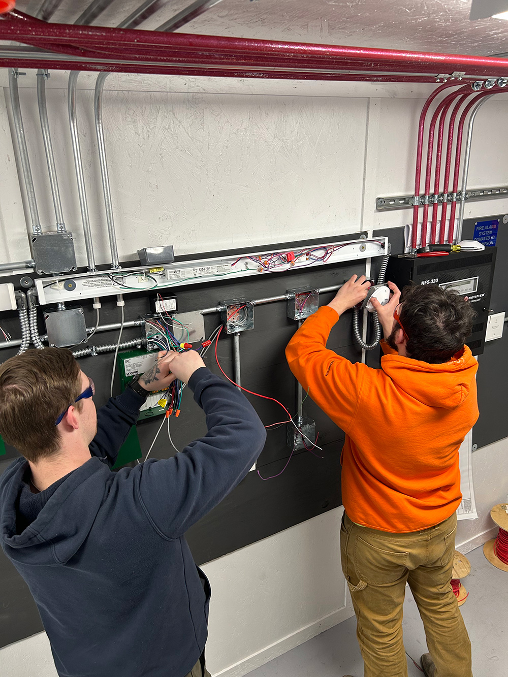 Students working on electrical projects in a classroom.